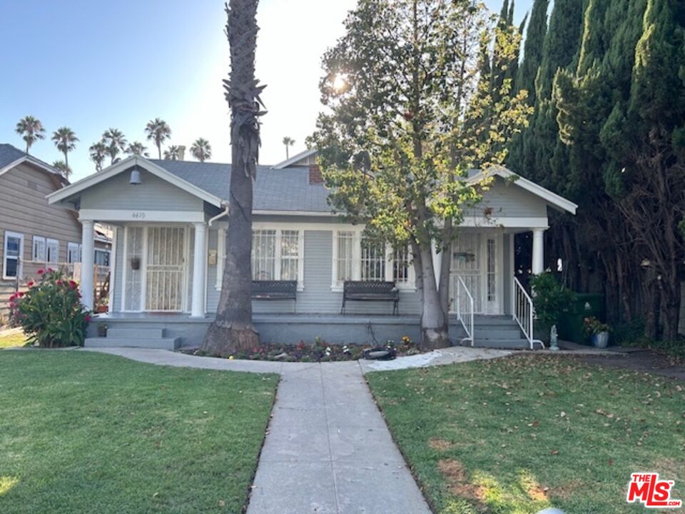 a front view of a house with a garden and plants