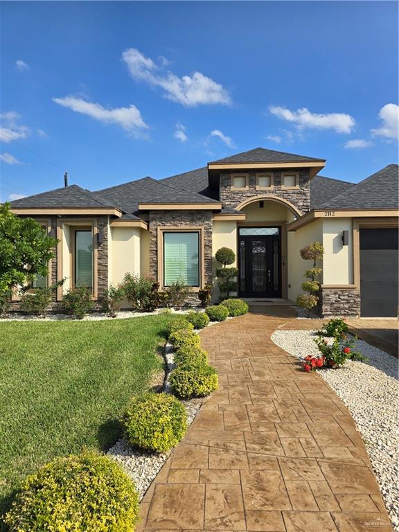 a front view of a house with a garden and yard