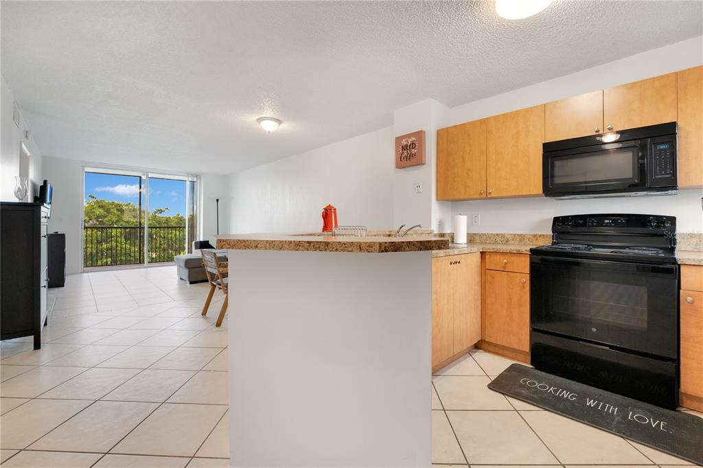 a kitchen with granite countertop a stove a sink and a microwave