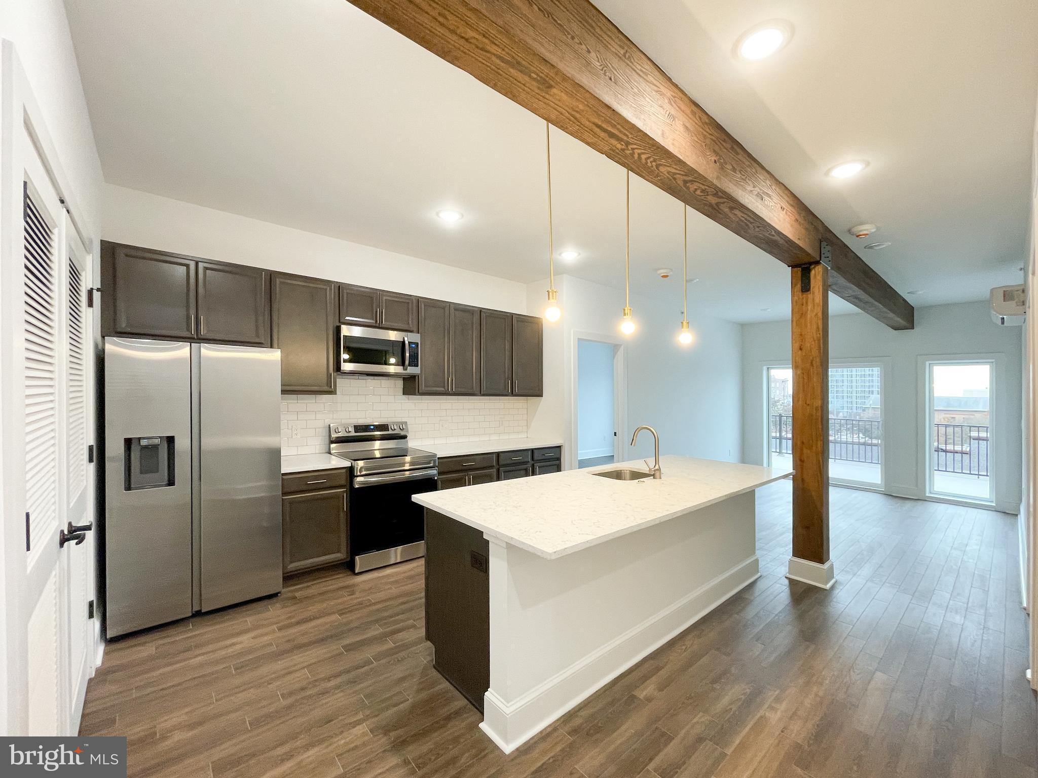 a large kitchen with kitchen island a sink stainless steel appliances and cabinets