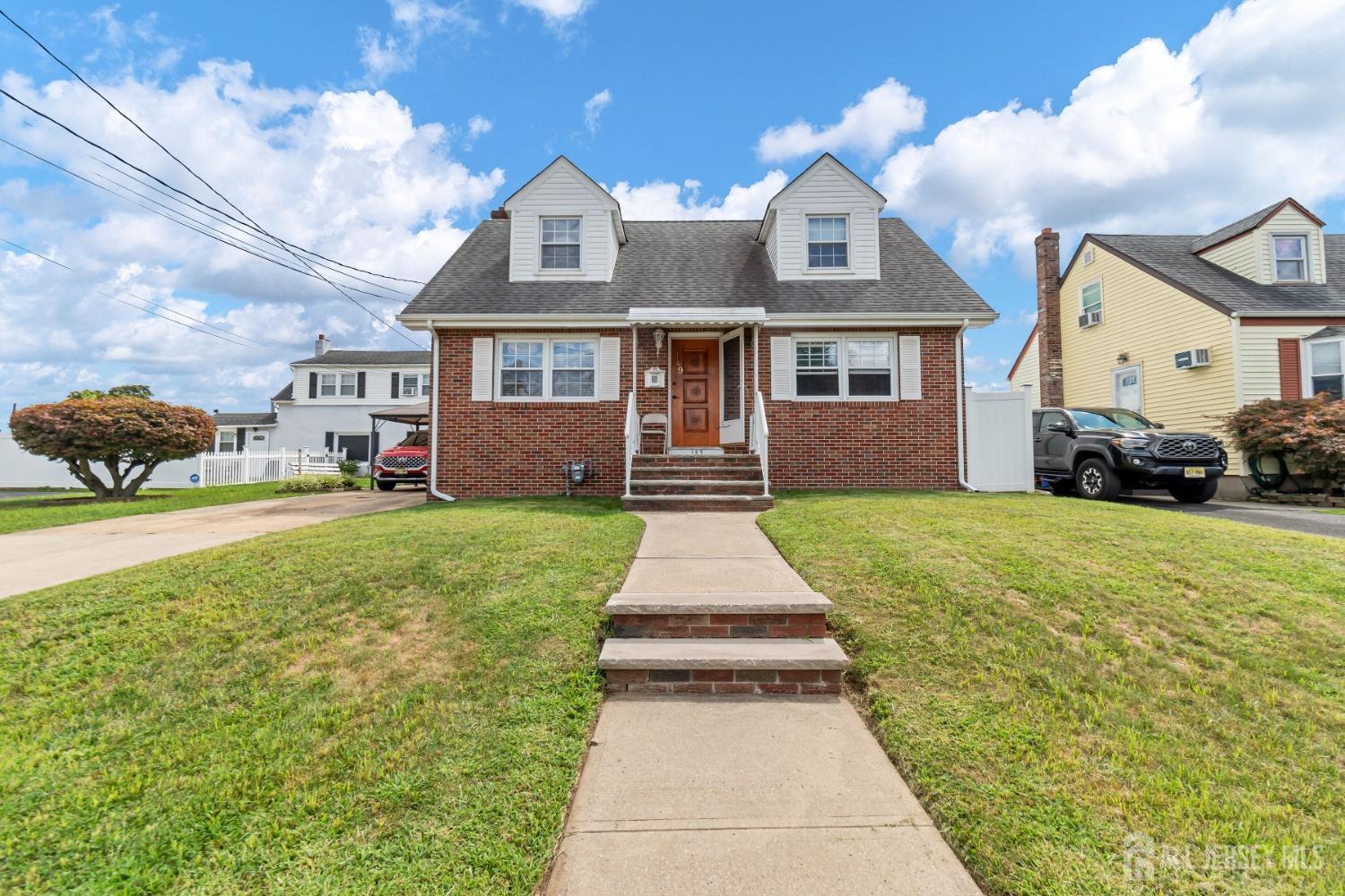 a front view of a house with a yard and potted plants