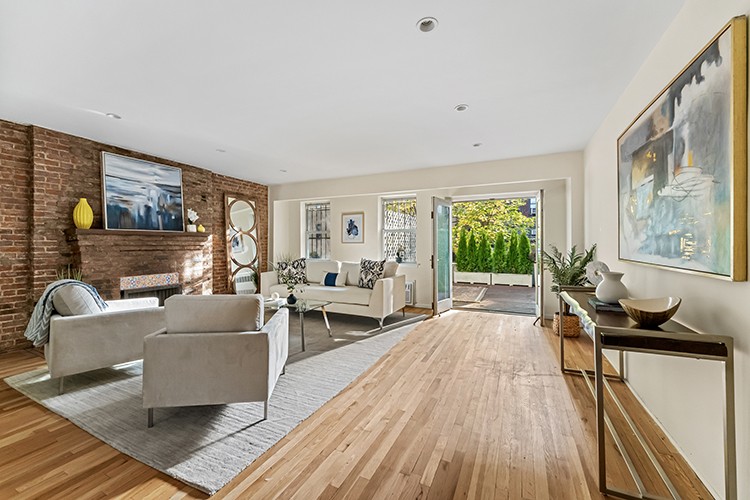 a living room with furniture large window and wooden floor