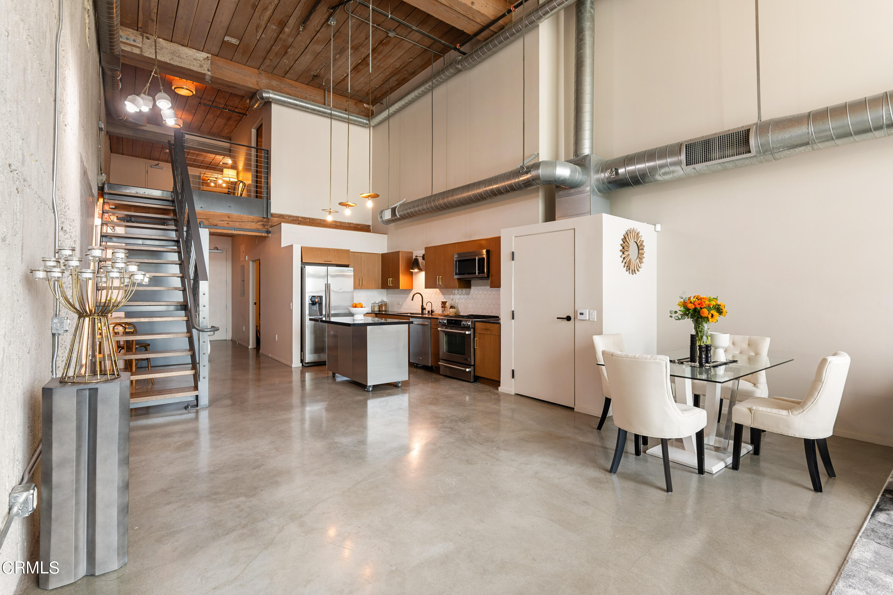 a kitchen with stainless steel appliances refrigerator cabinets and dining table