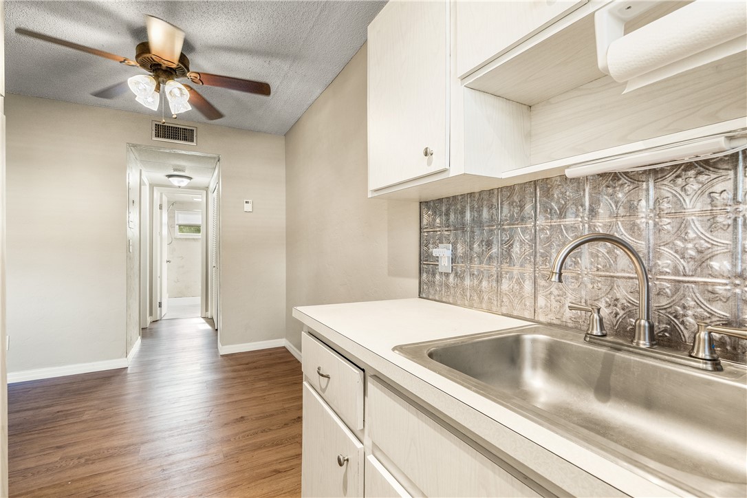 a kitchen with a sink cabinets a counter top space and stainless steel appliances