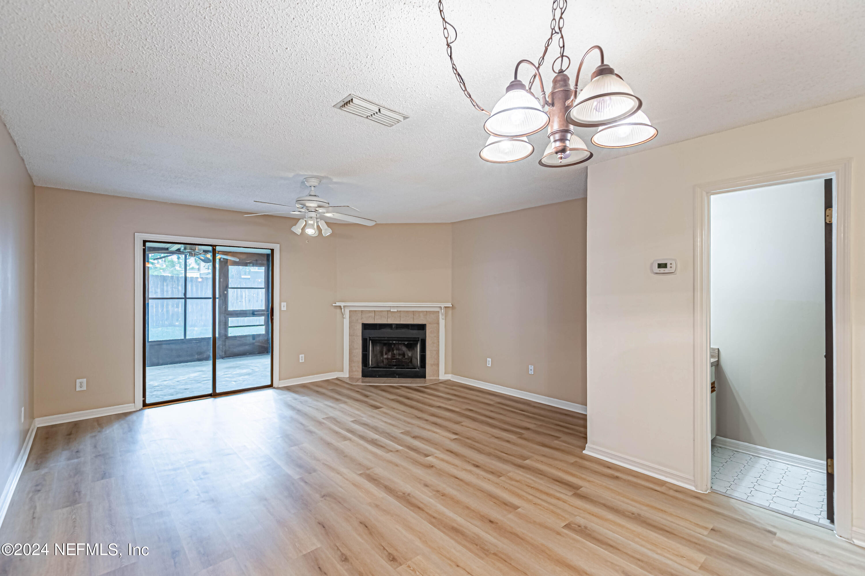 an empty room with wooden floor cabinet and windows