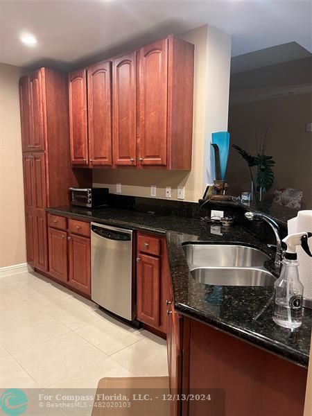 a kitchen with granite countertop a stove and a sink