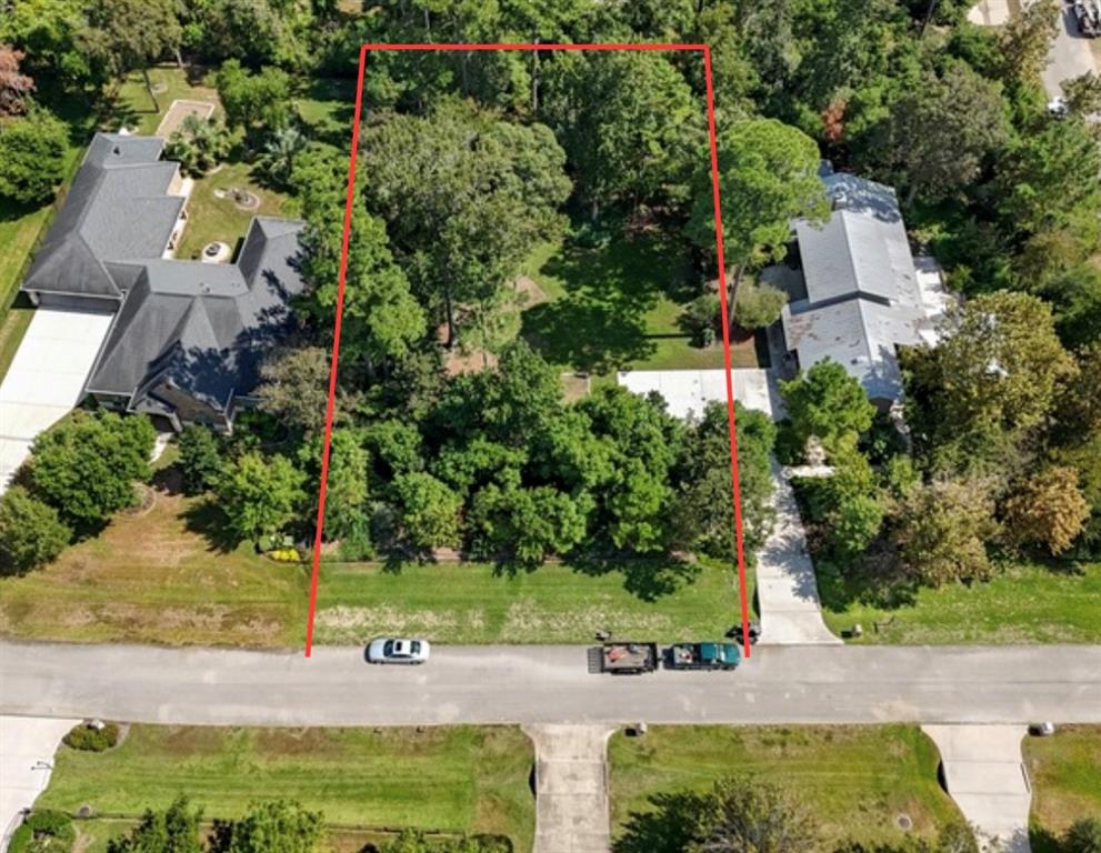 an aerial view of a house with a yard and greenery