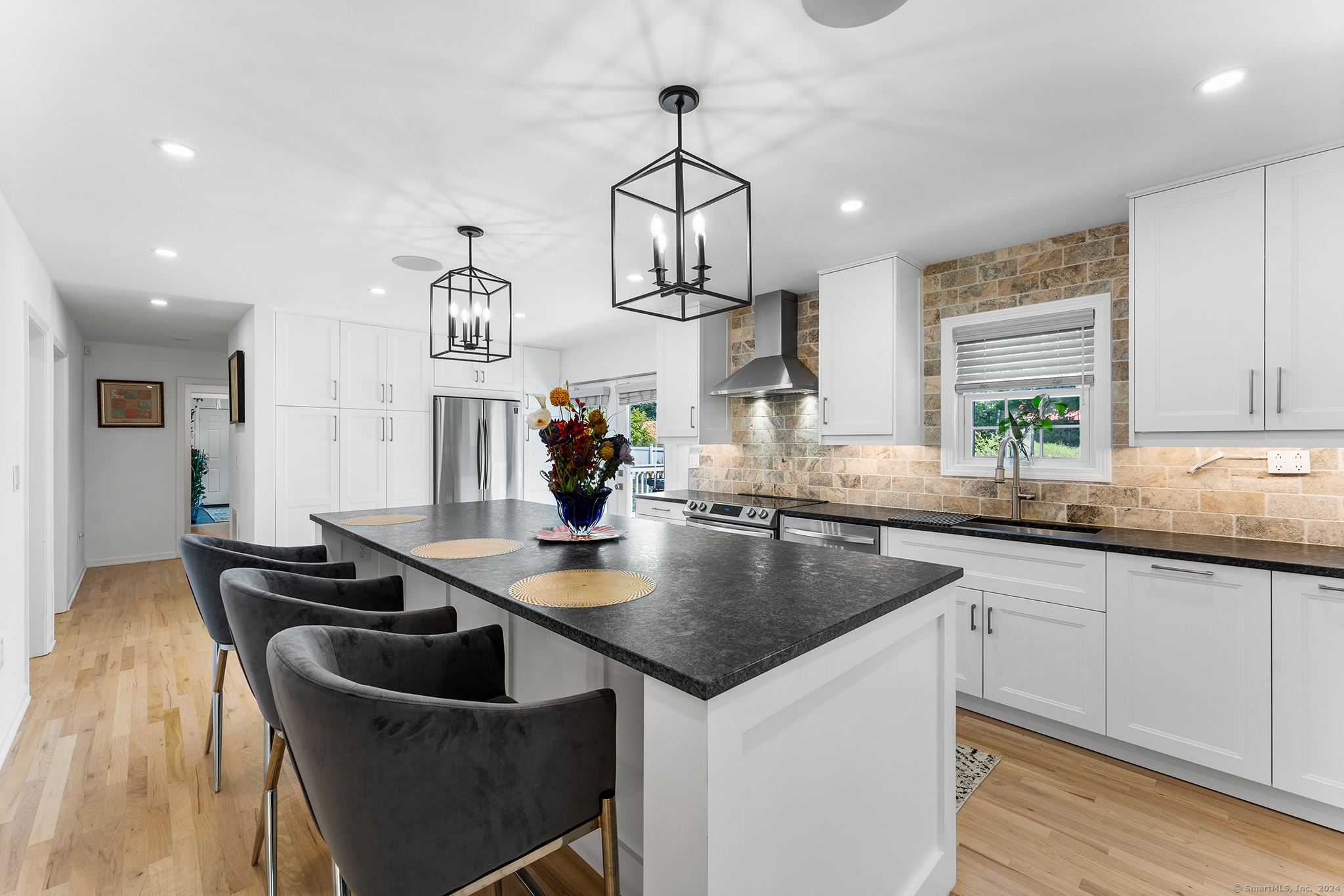 a kitchen with granite countertop a sink a stove and cabinets