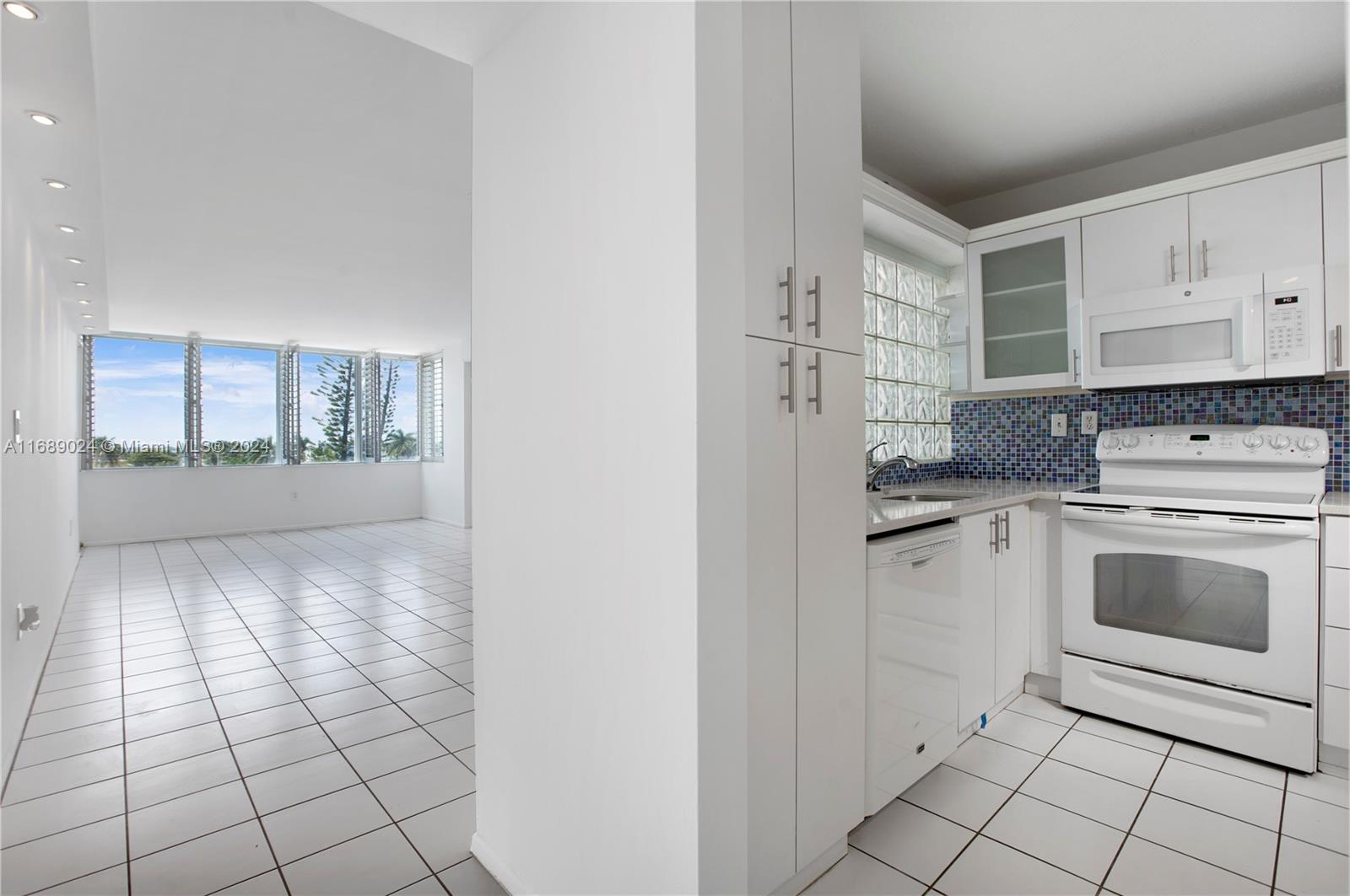 a kitchen with white cabinets and appliances