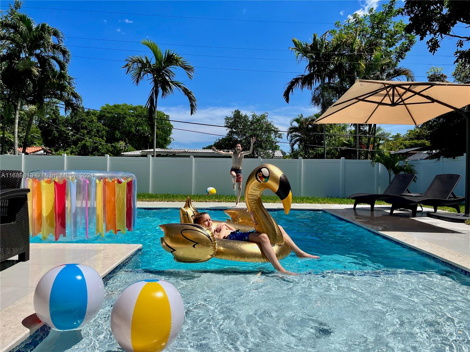 a view of a swimming pool with a patio and a slide