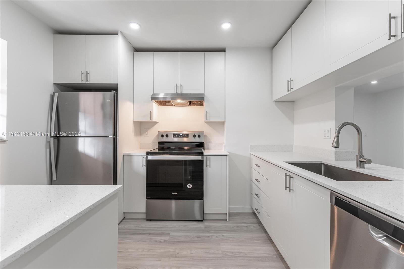 a kitchen with kitchen island a sink stainless steel appliances and cabinets