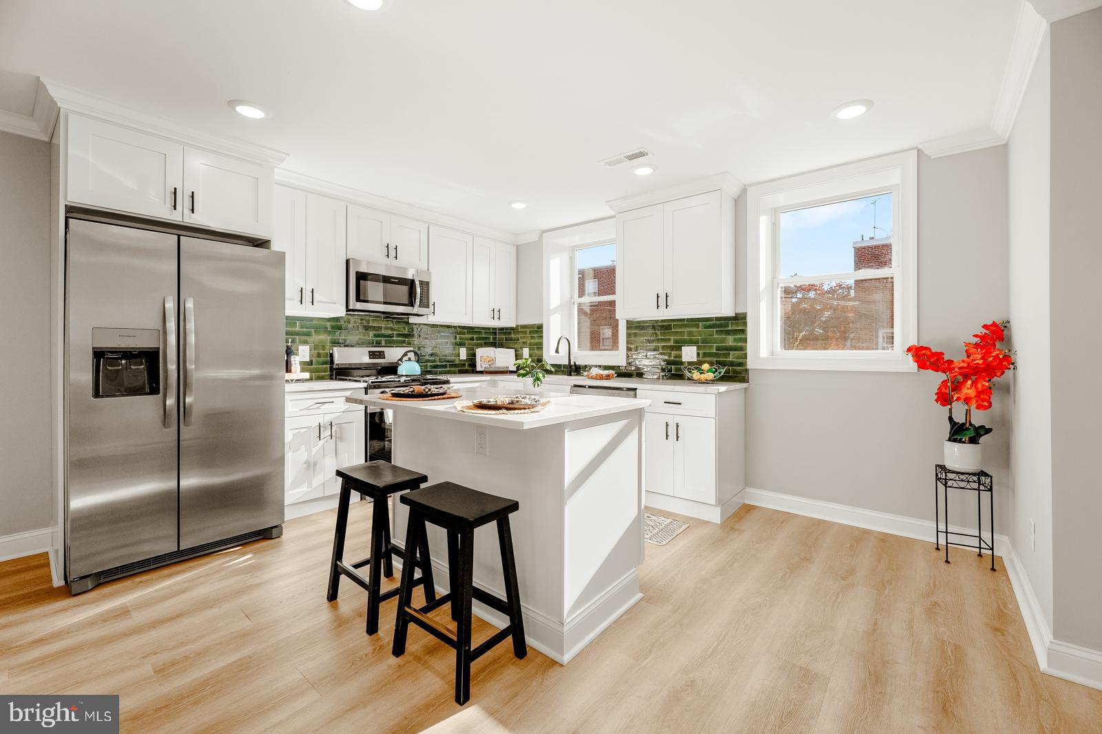 a kitchen with white cabinets and stainless steel appliances