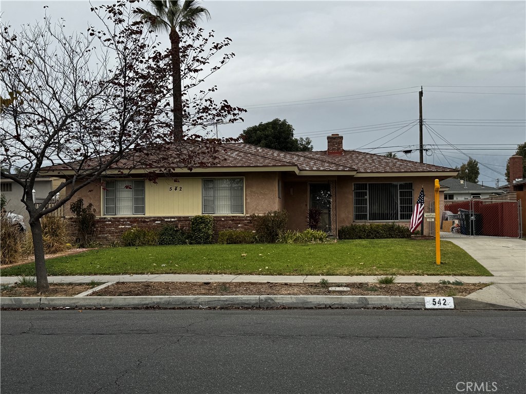 a front view of a house with a garden and plants