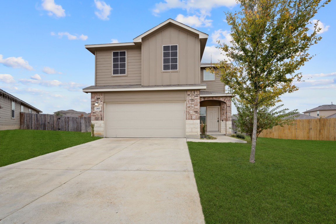 a front view of a house with a yard and garage