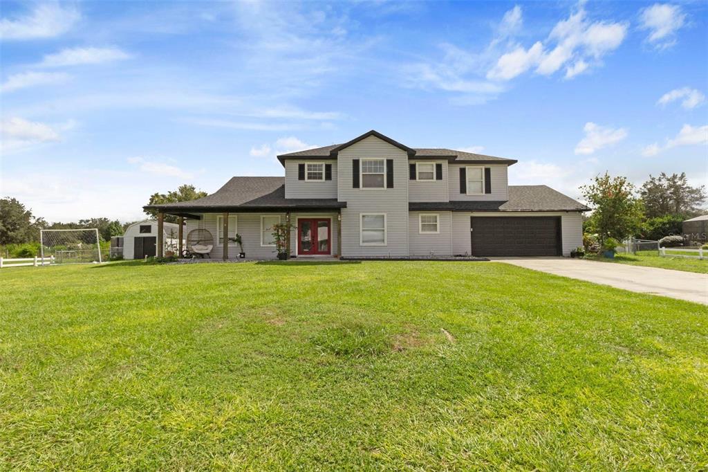 a front view of a house with a big yard