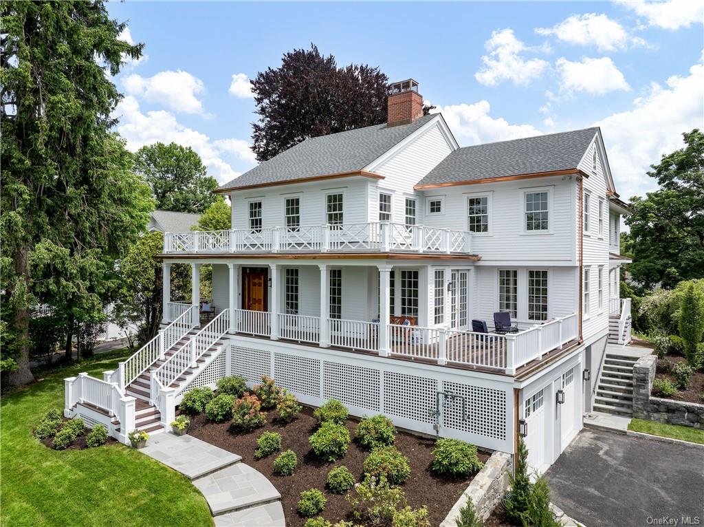 a front view of a house with a garden and trees