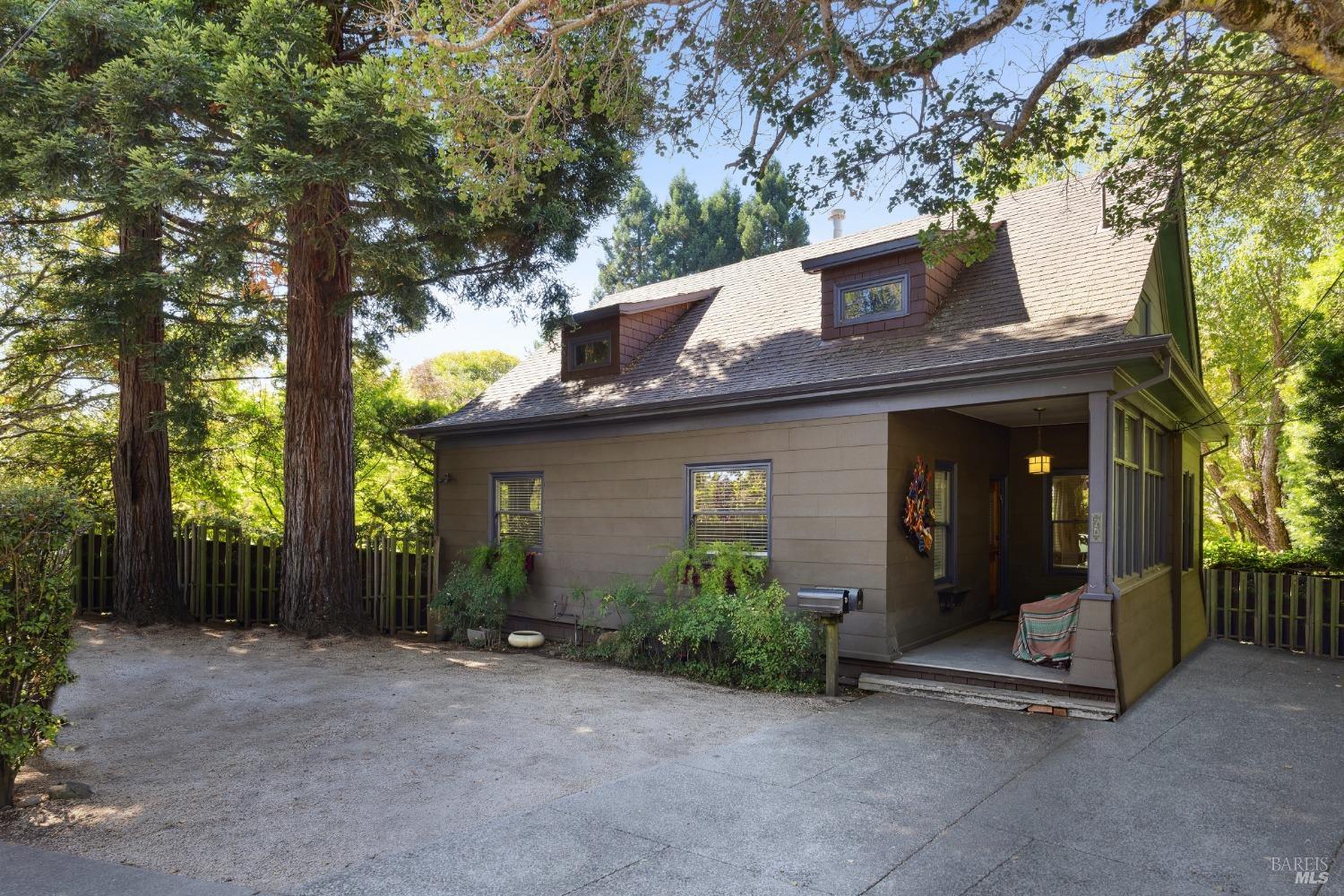 a view of a house with a plants and large tree