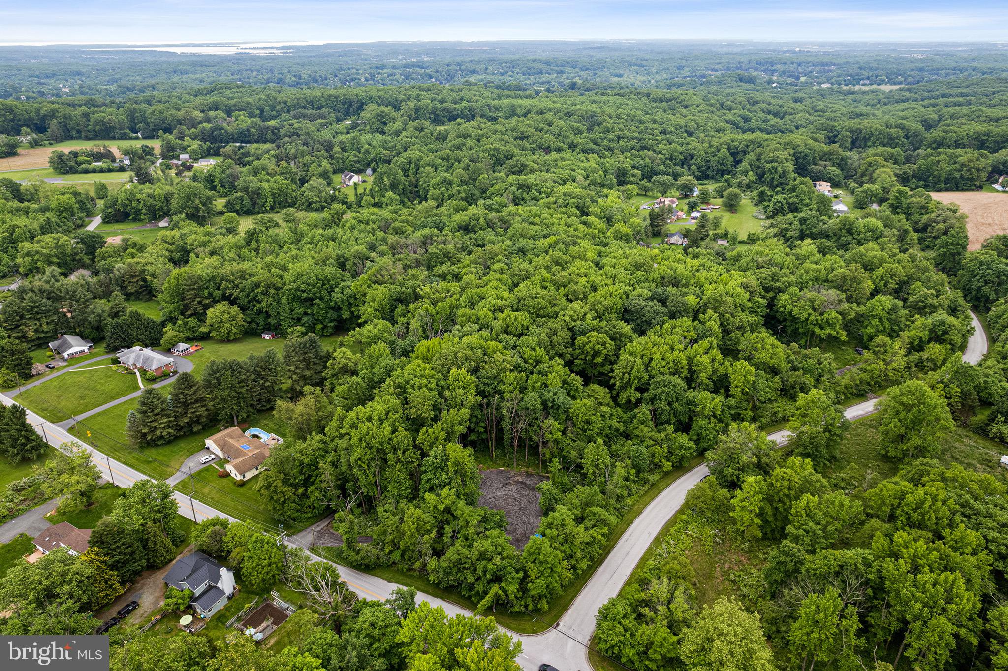 an aerial view of a house with a lush green forest