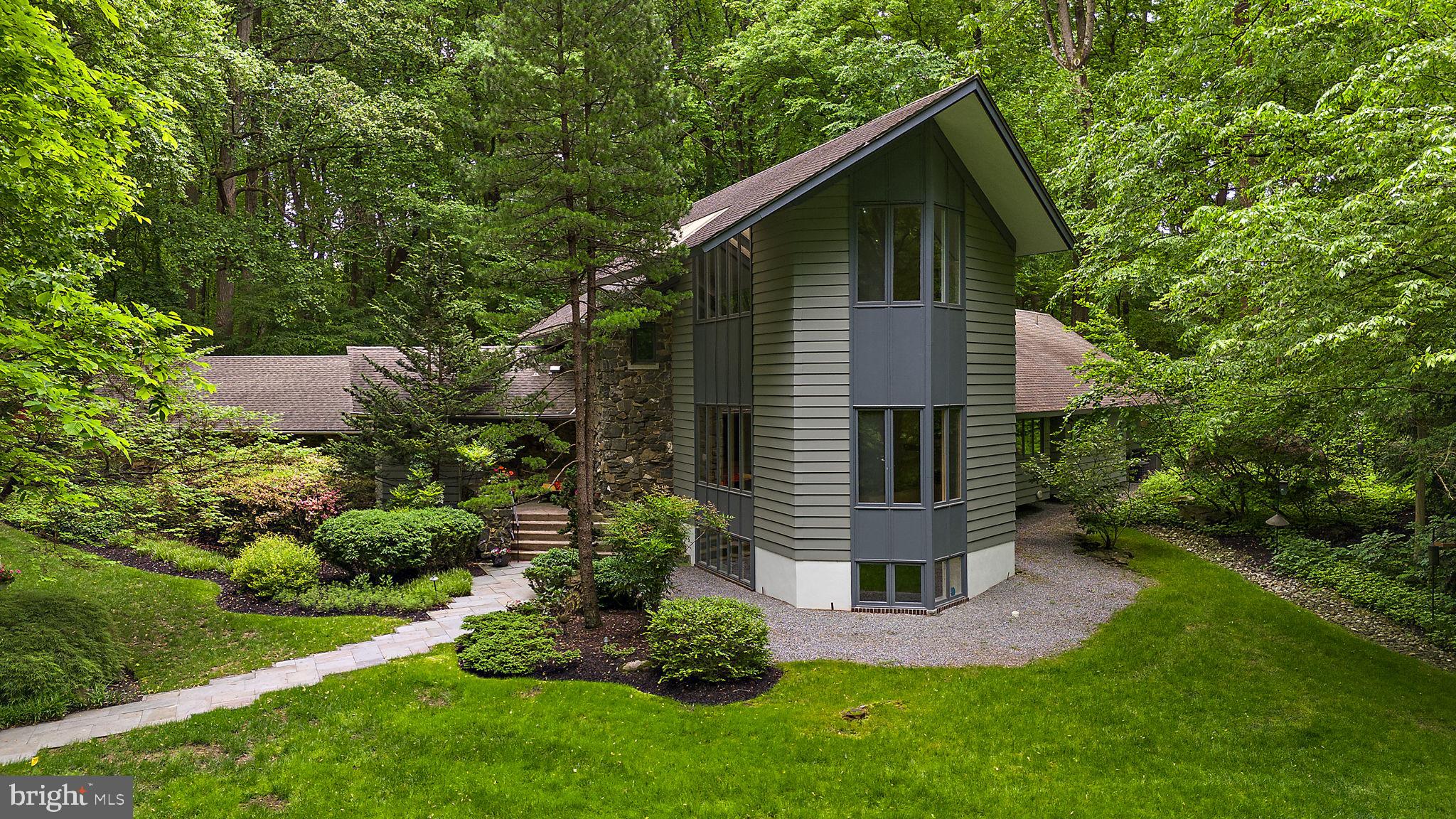 a view of a wooden house with a small yard and a large tree