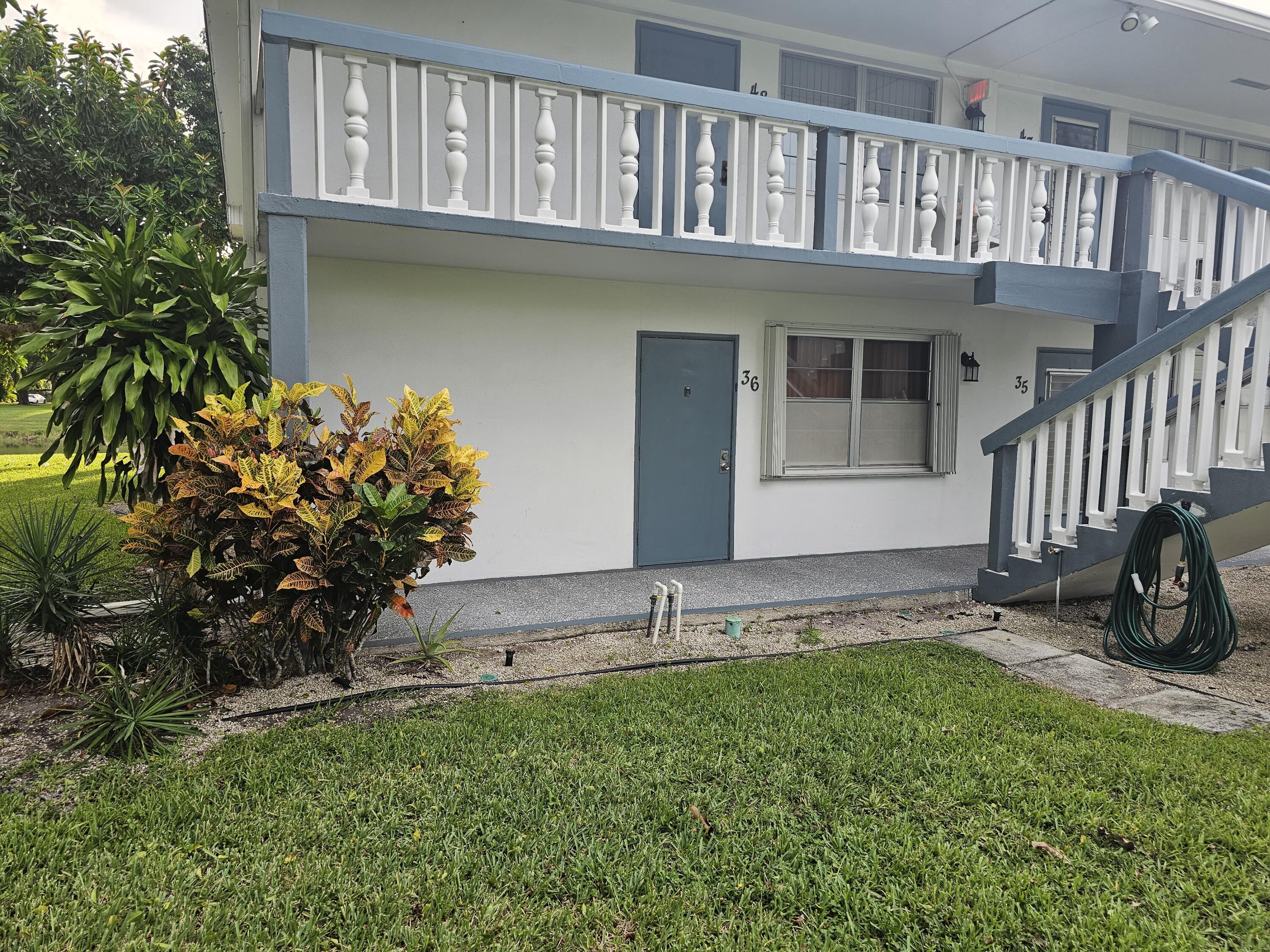 a view of a house with a small yard and wooden fence