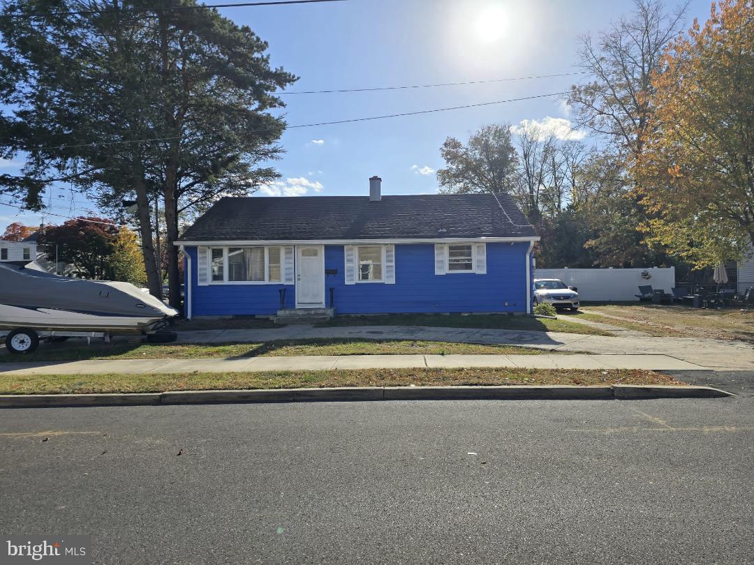 a view of a house with a yard and large tree