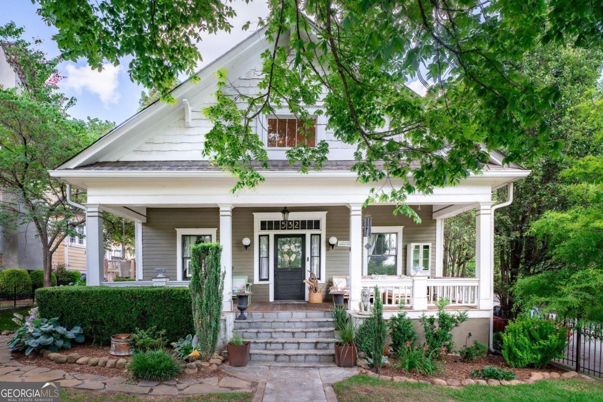 a front view of a house with porch and garden