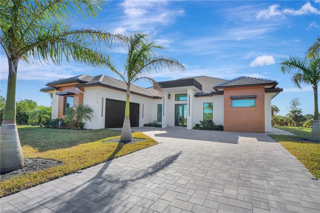 View of front facade featuring a front yard and a garage