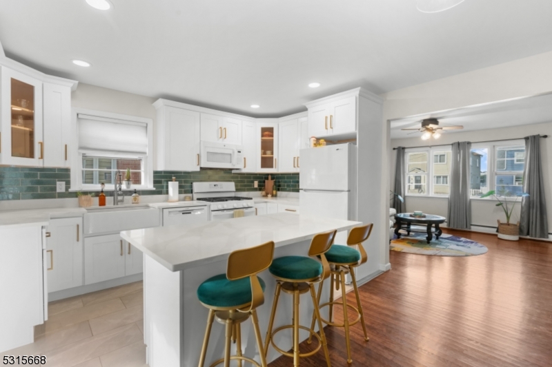 a large white kitchen with lots of counter space and furniture