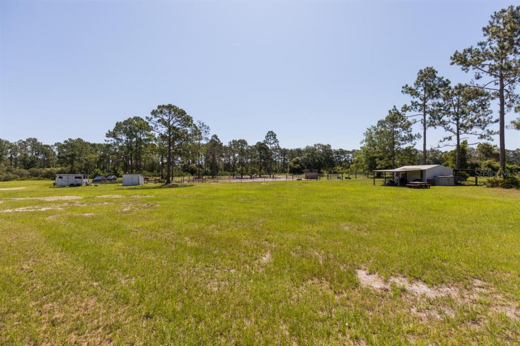 a view of yard with swimming pool and trees