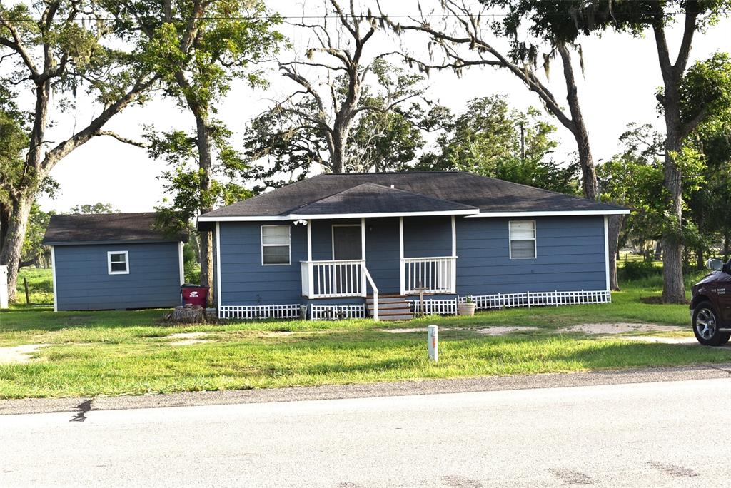 a view of a house with a yard and large tree