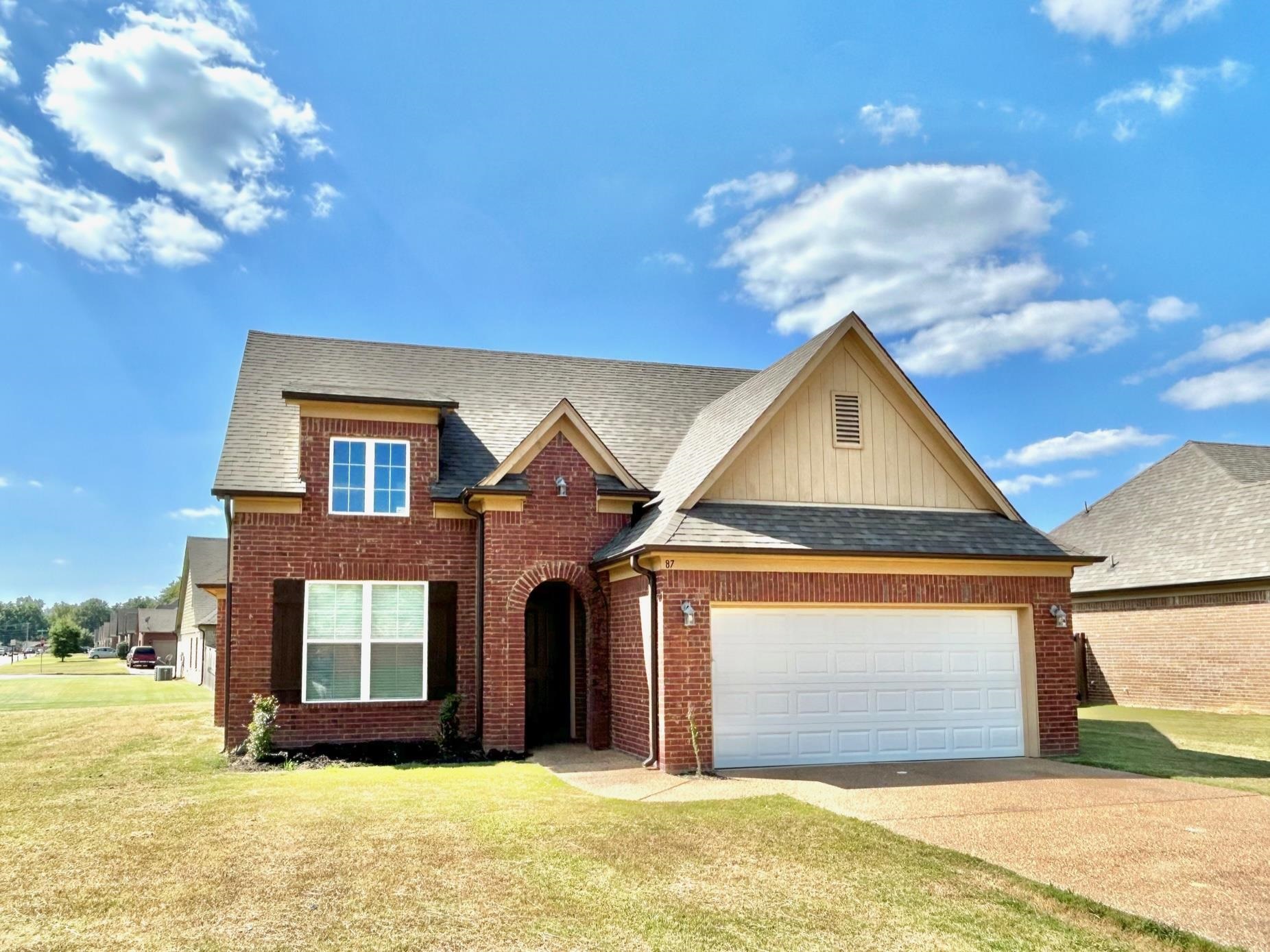 View of front of home with a front yard and a garage