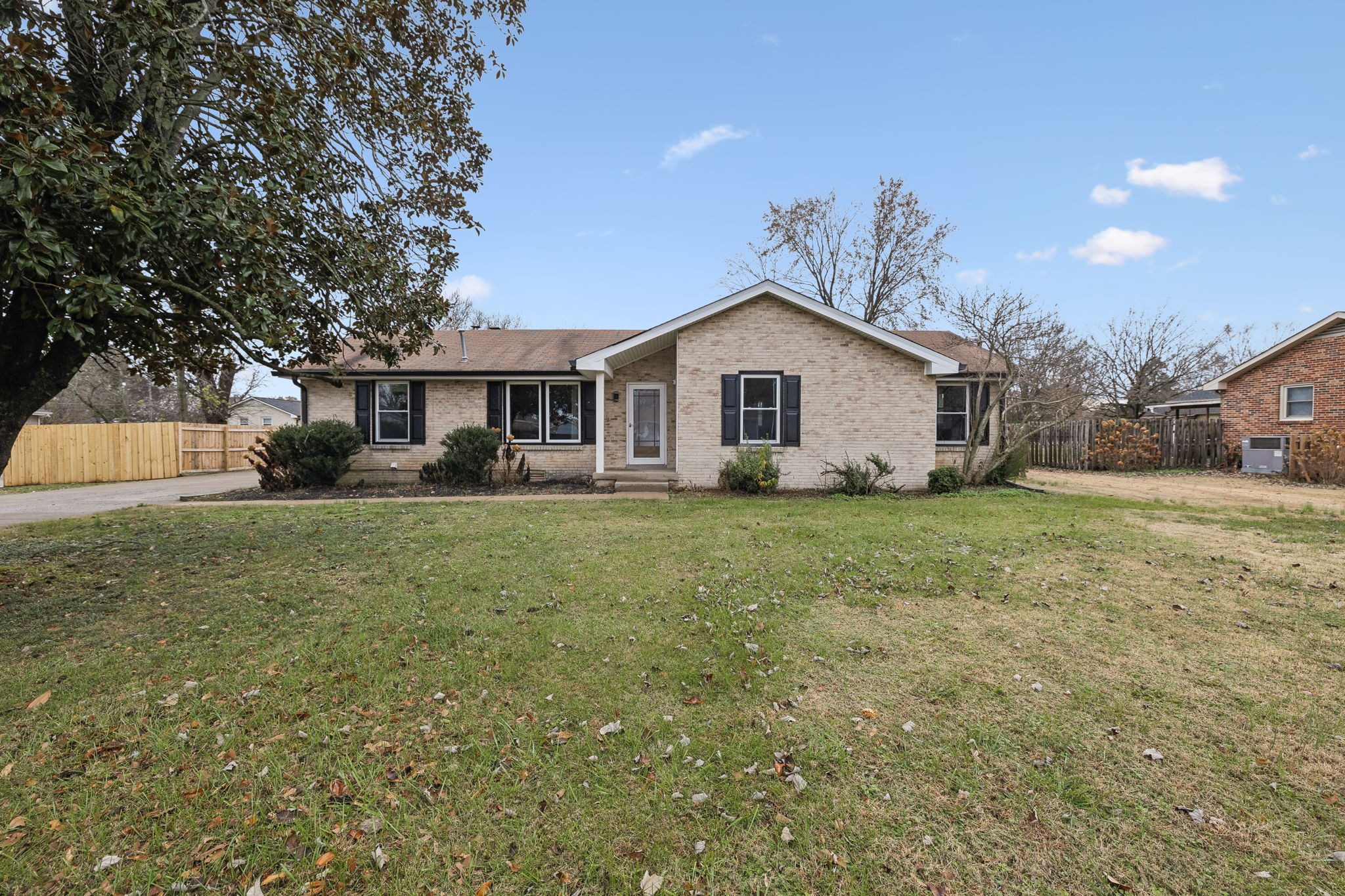 a front view of a house with a yard and trees