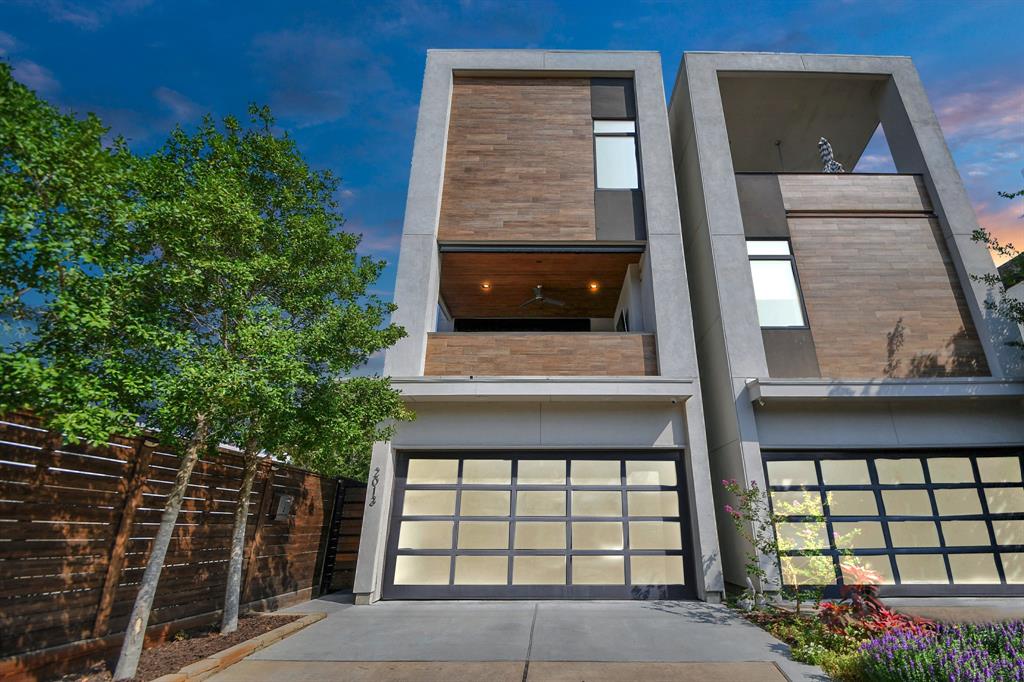 Modern three-story home with a unique architectural design featuring large windows, a spacious two-car garage, and a mix of stucco and tile façade finishes. The property includes a gated entry and a balcony, offering privacy and outdoor space.