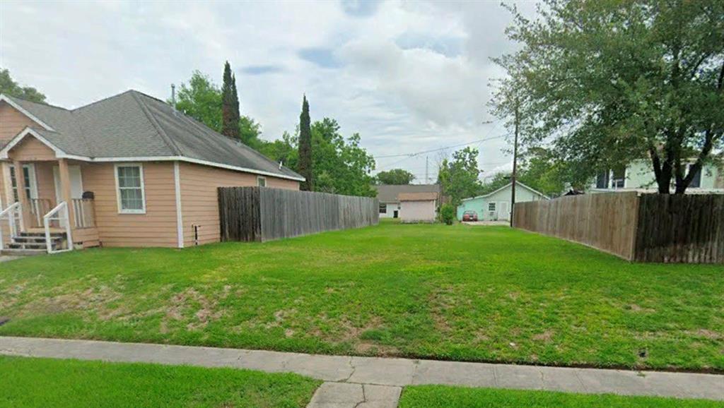 a view of a backyard with table and chairs and wooden fence