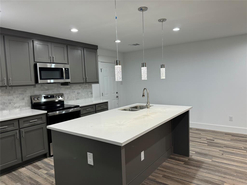 a kitchen with a sink a stove a microwave and cabinets