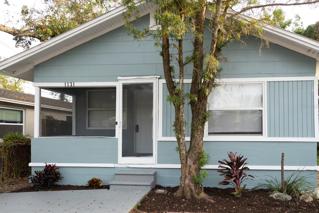 a front view of a house with a tree