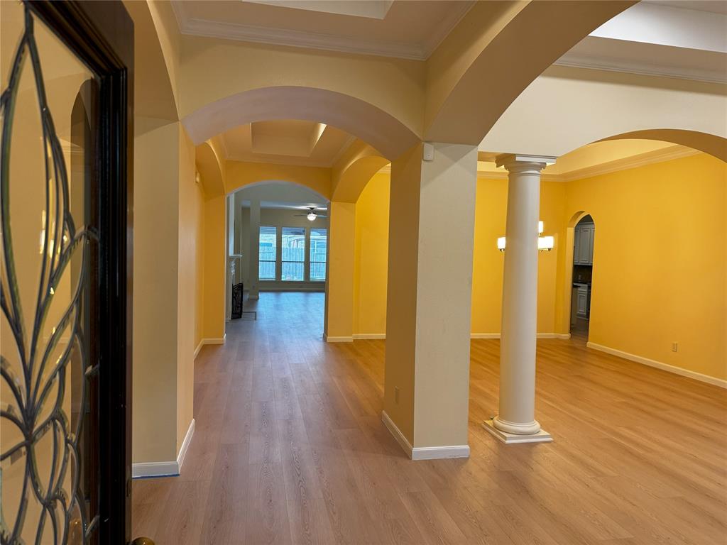 a view of a hallway with wooden floor and a glass door