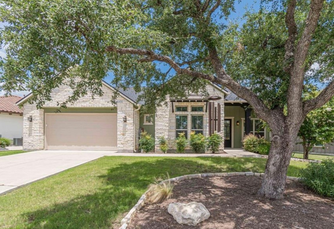 front view of a house with a yard and an trees