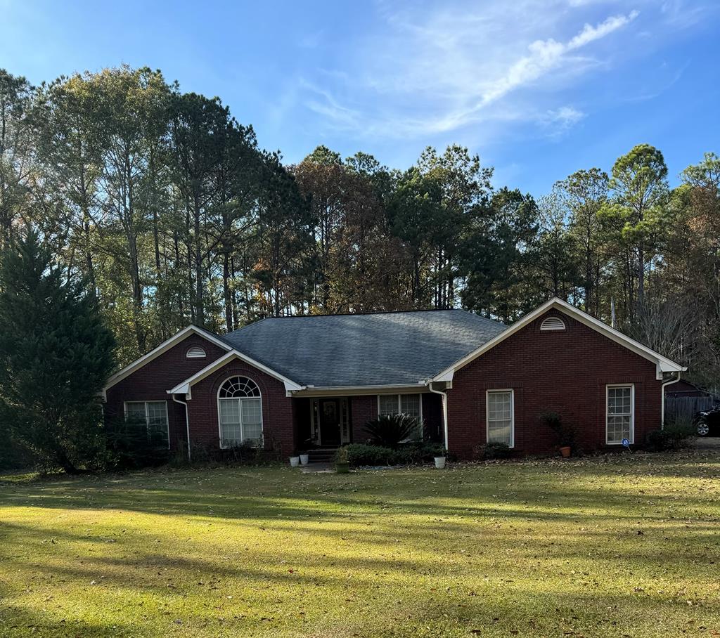 a front view of a house with a yard and trees