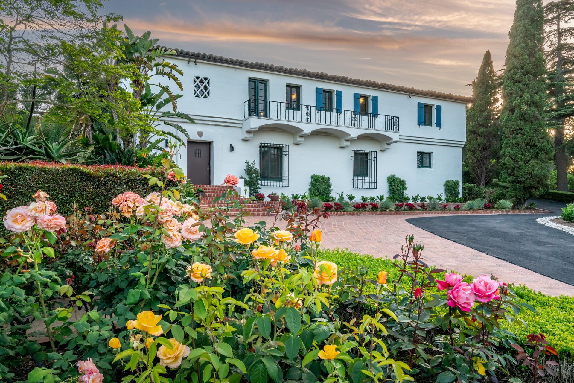 a front view of a house with lots of flowers