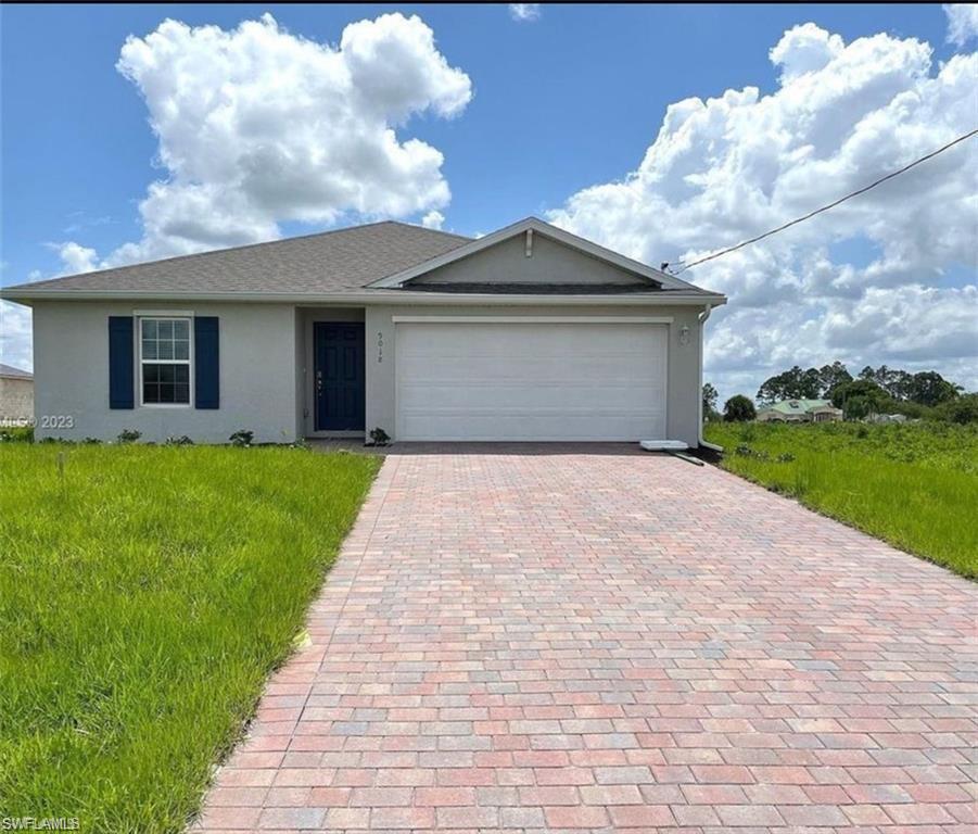 View of front of home with a garage and a front yard