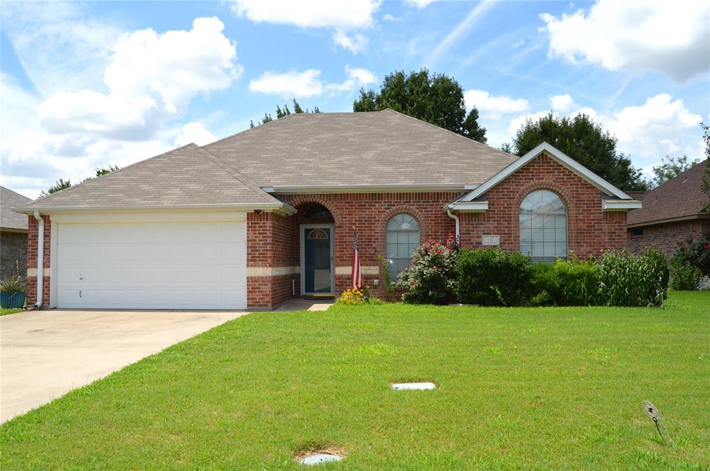 a front view of a house with yard and green space