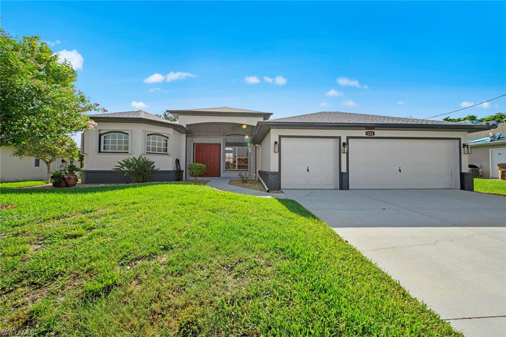 a view of a house with yard and a garage