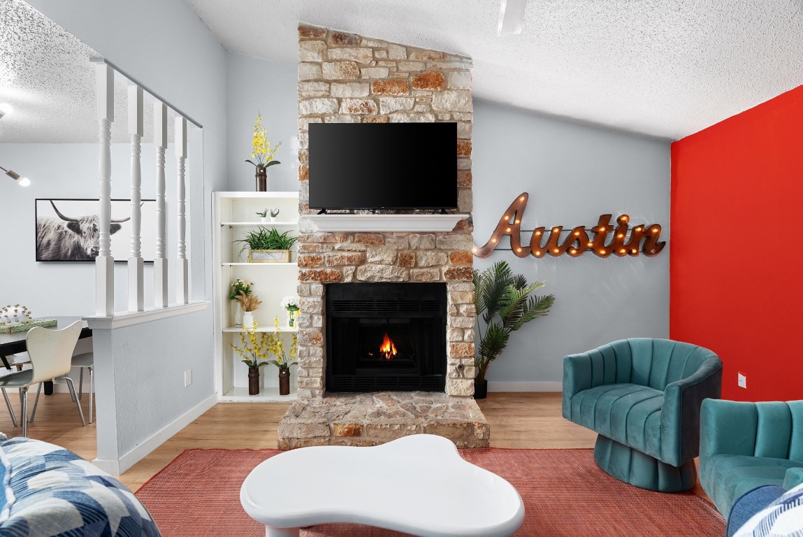 a living room with furniture a flat screen tv and a fireplace