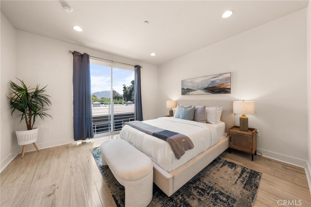 a bedroom with a large bed and a potted plant