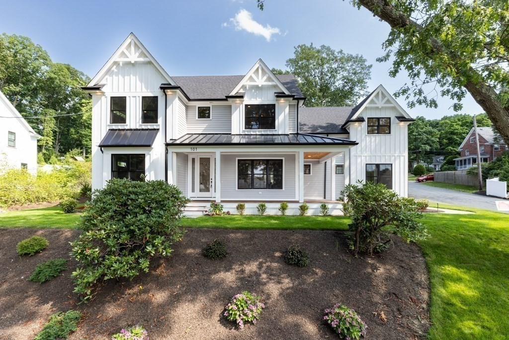 a front view of a house with a yard and potted plants