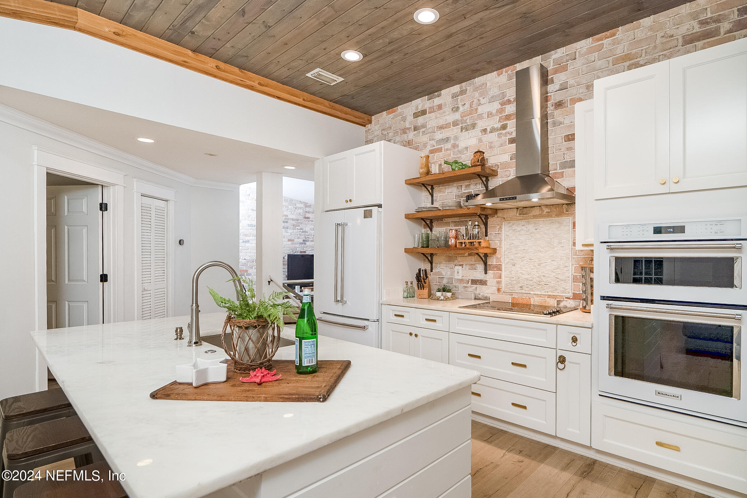 a kitchen with kitchen island stainless steel appliances a sink stove and white cabinets