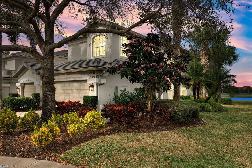 a front view of a house with a yard and a garden