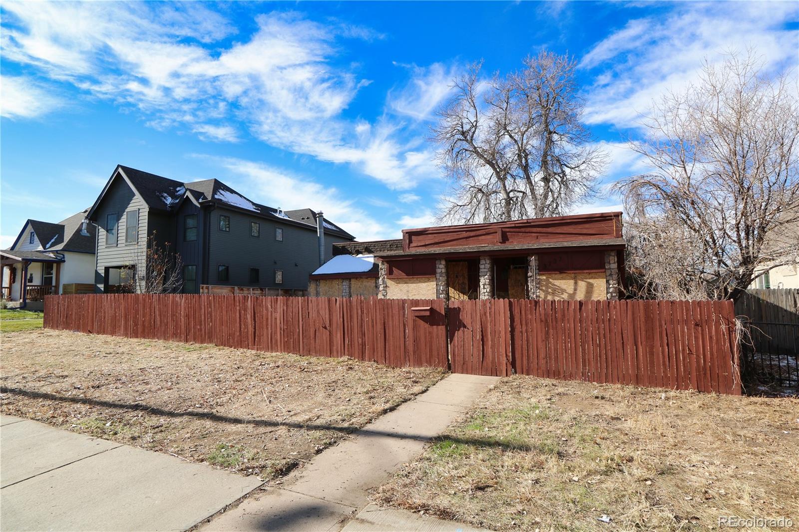 a view of a house with a wooden fence