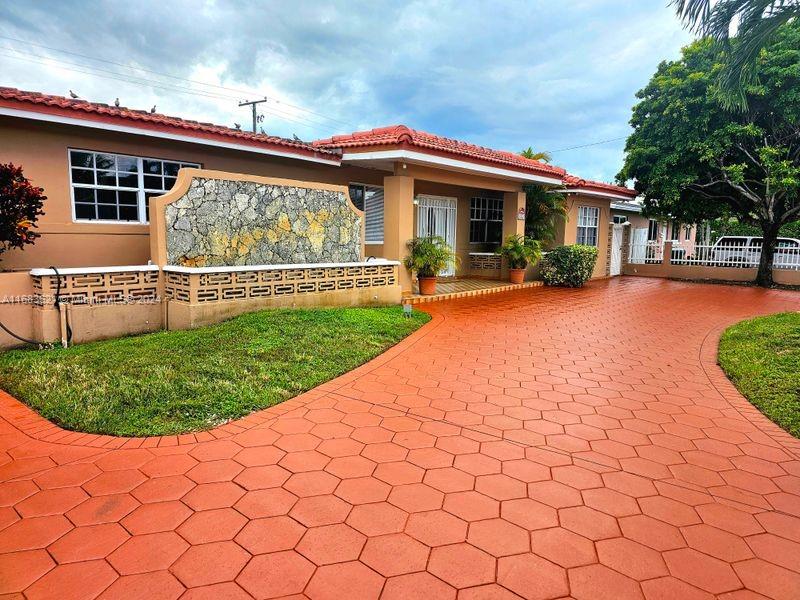 a view of a house with a yard and sitting area